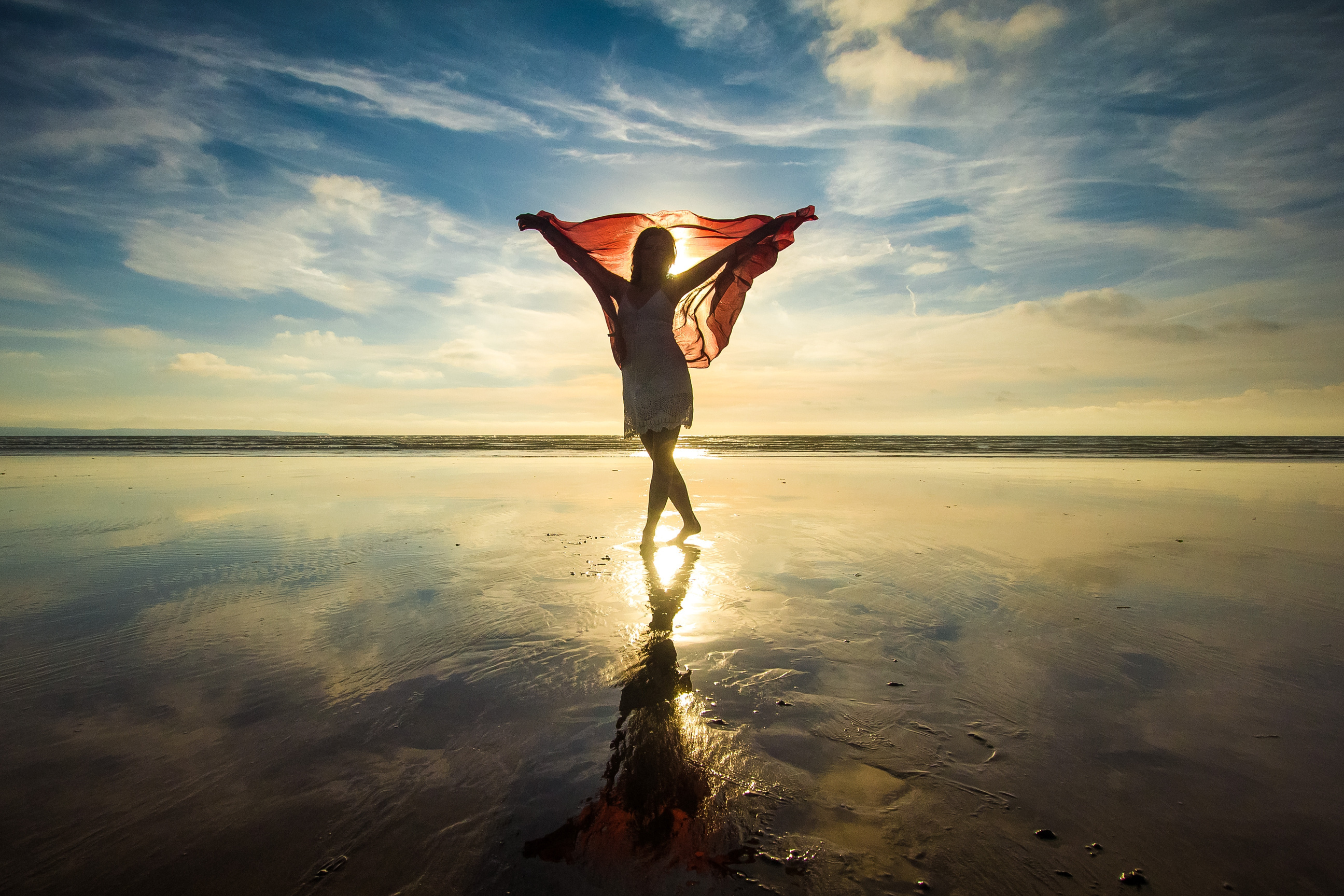 Silhouette of a Woman Holding a Shawl by the Beach